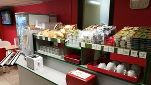 Ein Frühstücksbuffet mit verschiedenen Speisen, einer Uhr und einem Kühlschrank.