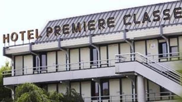 Ein Hotel namens „HOTEL PREMIERE CLASSE“ mit moderner Architektur, inklusive flachem Dach und einem Balkon im oberen Stockwerk.