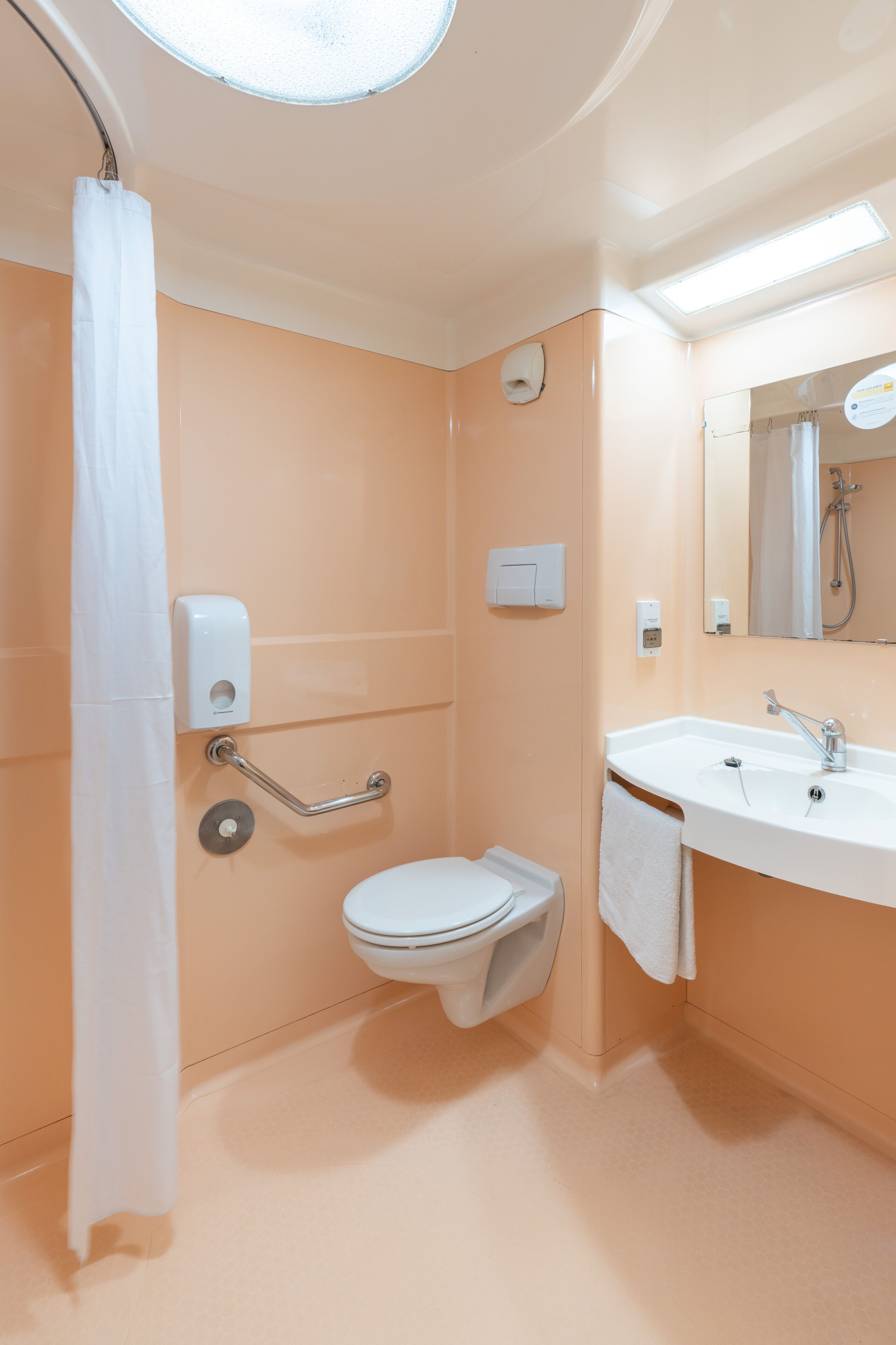 Ein Badezimmer mit Toilette, Waschbecken und Handtrockner.
