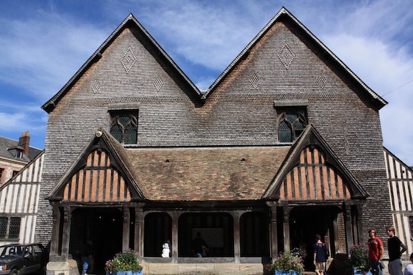 A traditional half-timbered building with a steeply pitched roof, large windows, and a central entrance with a covered porch. - Première Classe Deauville - Touques (Touques)