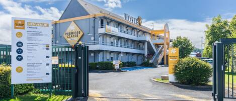 A hotel entrance with a sign indicating a welcome message and amenities like a buffet.