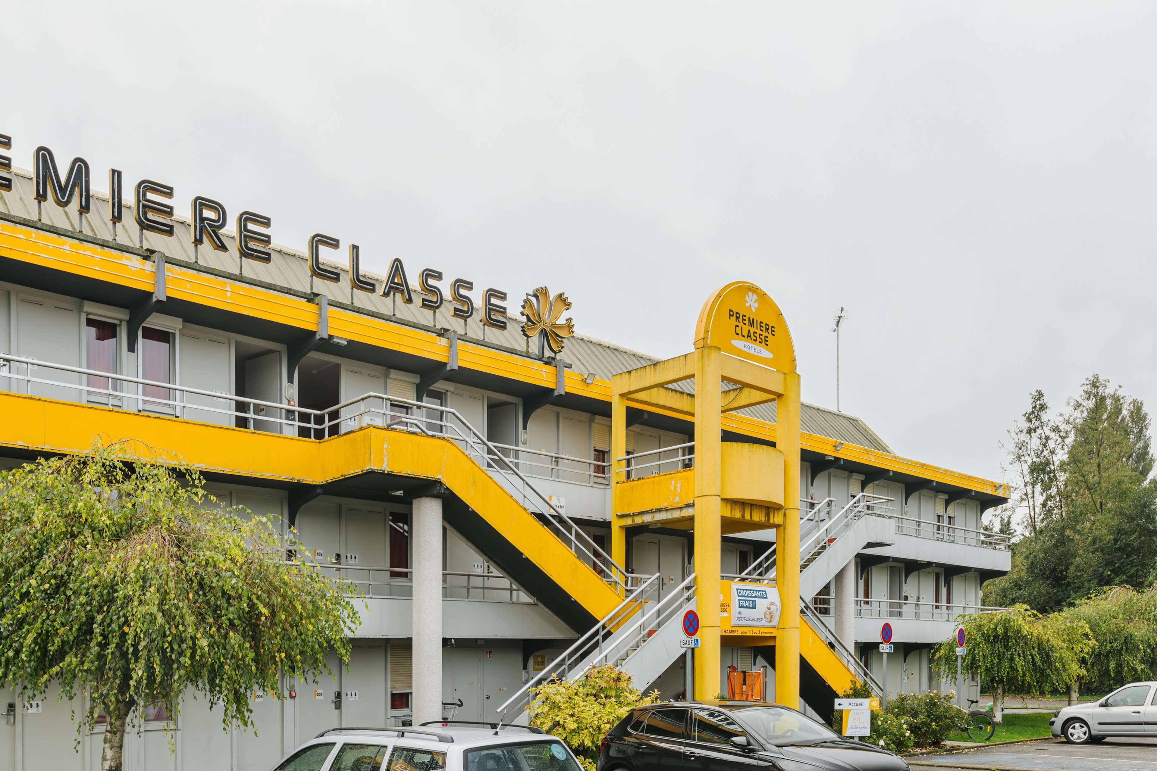 En bygning med et skilt, hvor der står "Premiere Classe", og en trappe, der fører op til en etage.