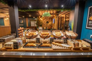A breakfast buffet with various breads, pastries, and jams. - Premiere Classe Laon (Laon)