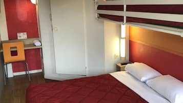 Ein Zimmer mit Etagenbetten, einem Schreibtisch und einem Stuhl.