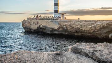 Un faro sobre un promontorio rocoso con una vista despejada del mar.