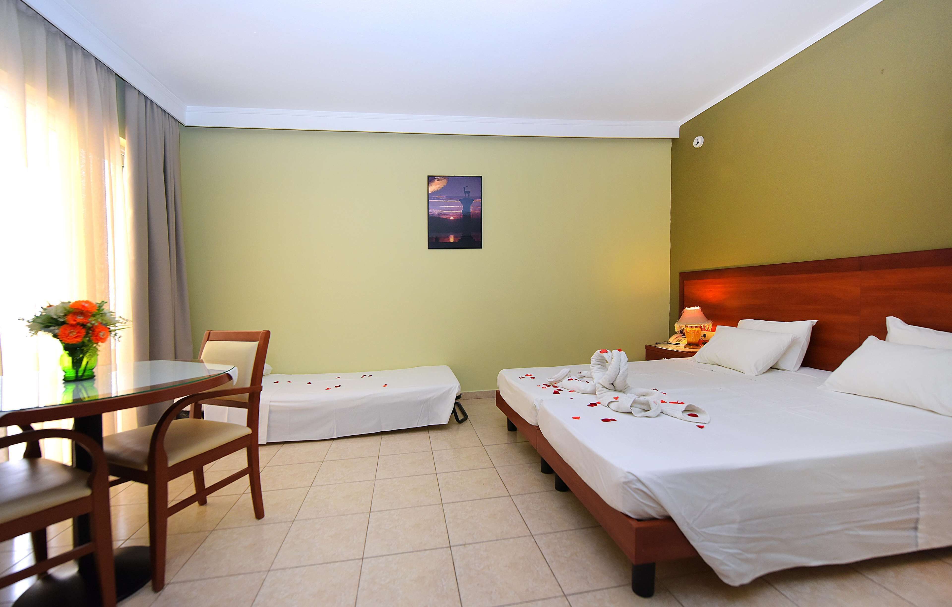 A hotel room with two beds, a desk, and a chair.