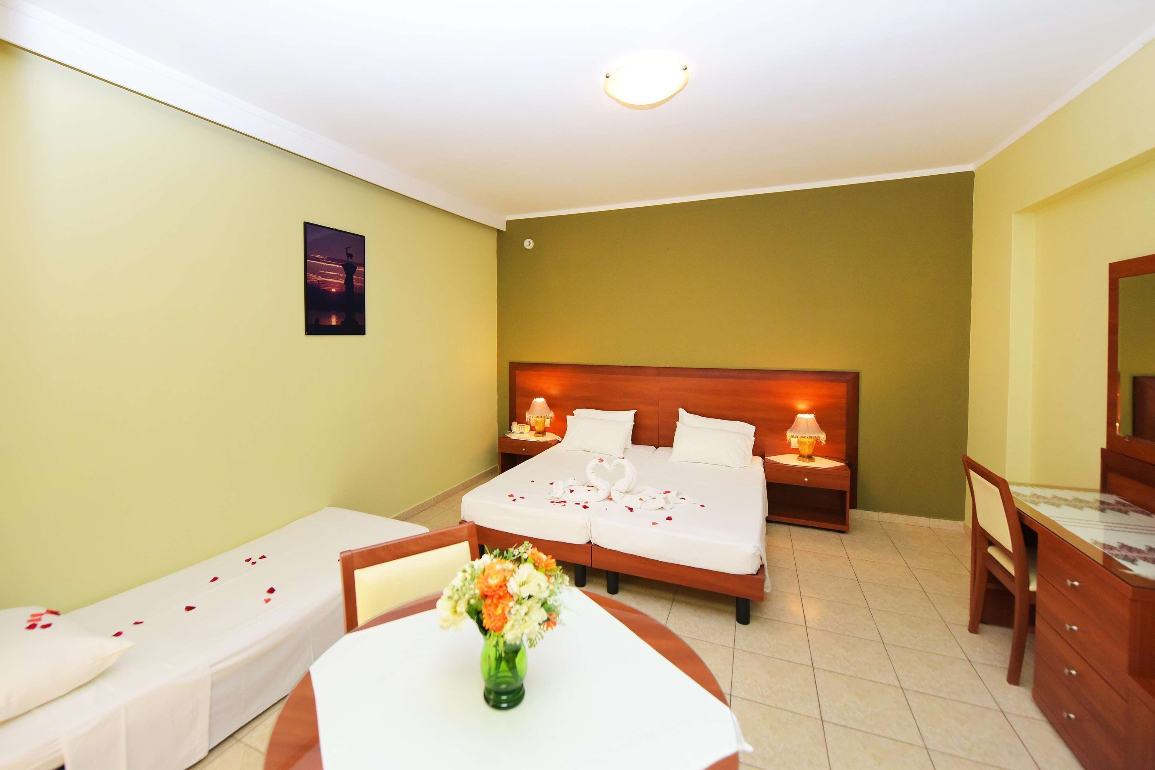 A hotel room with a bed, bedside tables, a desk, and a chair.