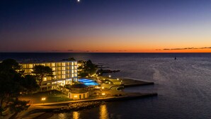 A resort with a swimming pool, a large building with multiple floors, and a view of the sea at dusk. - Hotel Sipar Plava Laguna (Umag)