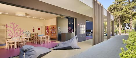 An outdoor seating area with bean bags and a children's play area with tables and chairs.