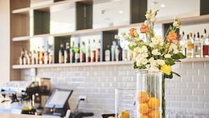 A bar area with a glass vase containing flowers and citrus fruits on the counter. - Hotel Sipar Plava Laguna (Umag)
