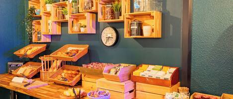 Un bufé de desayuno con diversos alimentos y un reloj en la pared.