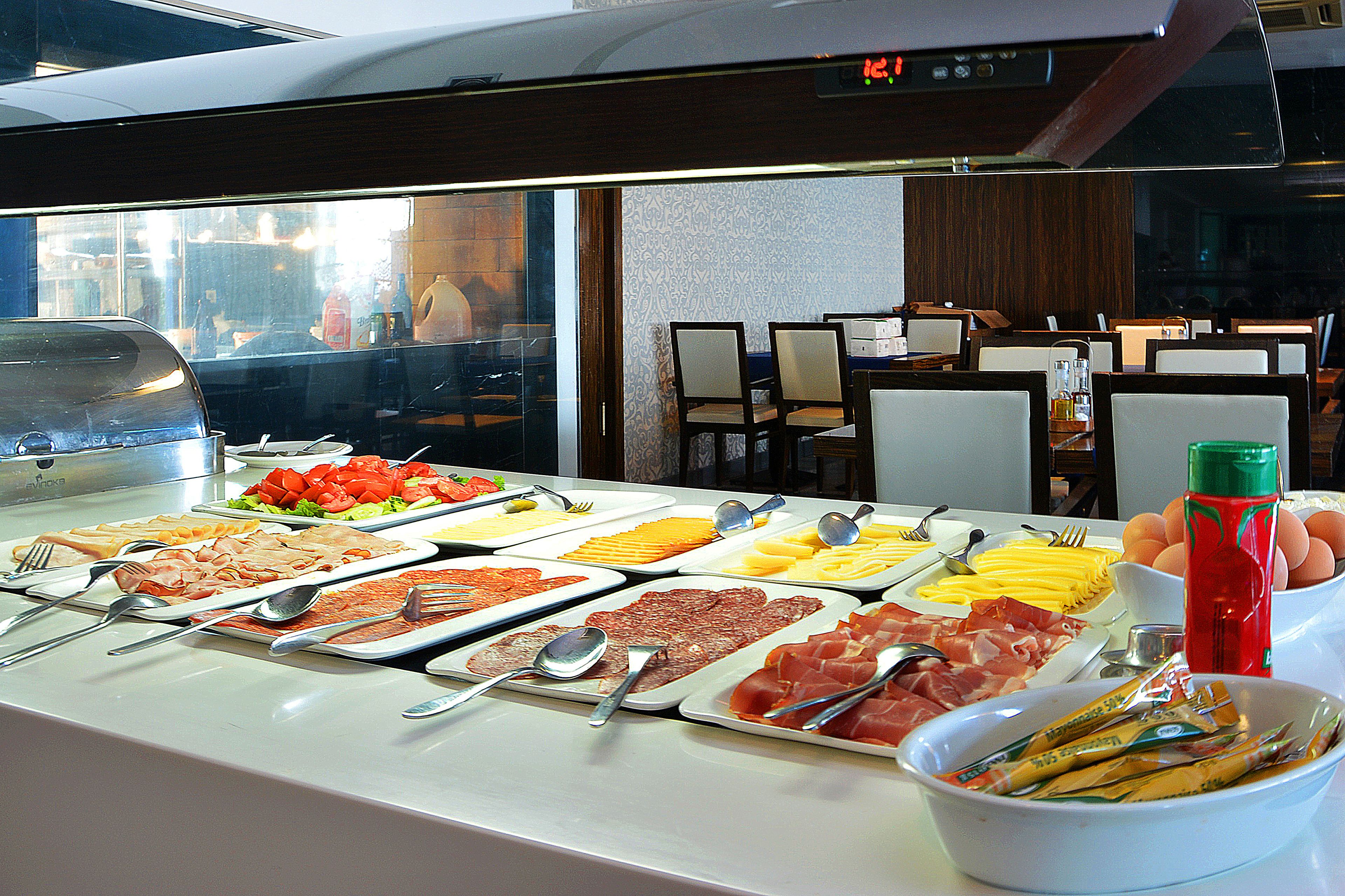 A buffet with various food items and utensils.