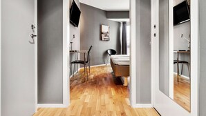 A modern hotel room with a wooden floor, a bed, a desk, and a chair. - Sure Hotel by Best Western Stockholm Alvsjo (Älvsjö)