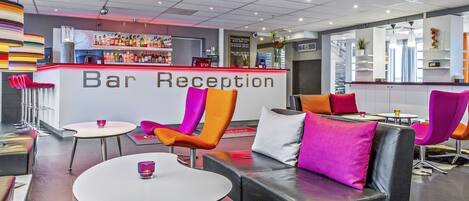 Un espace de réception avec un bar, comprenant un comptoir, des chaises, des tables et un aménagement intérieur moderne.