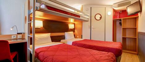 A compact hotel room with two beds, a desk, and a TV.