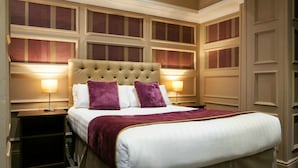 A hotel room with a large bed, two bedside lamps, and a decorative headboard.