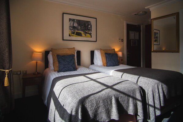 A hotel room with two beds, a framed picture on the wall, and a door to the right. - Dublin Citi Hotel (Dublin)