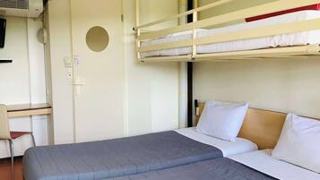 Une chambre avec un lit superposé, un bureau et une chaise, une porte et un climatiseur fixé au mur.