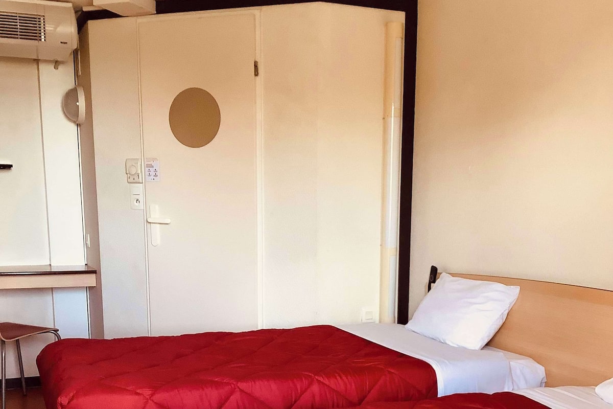 Ein Hotelzimmer mit einem großen Bett, einem Schreibtisch und einem Kleiderschrank.