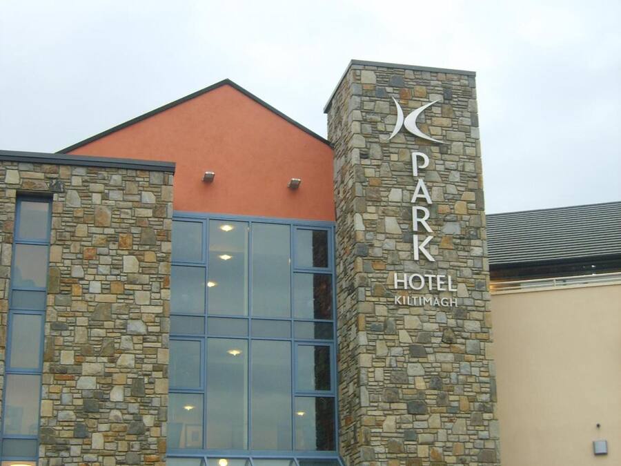 Un hotel con fachada de piedra y amplias ventanas de vidrio.