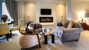 Una sala de estar moderna con chimenea, asientos cómodos y un televisor de pantalla plana.