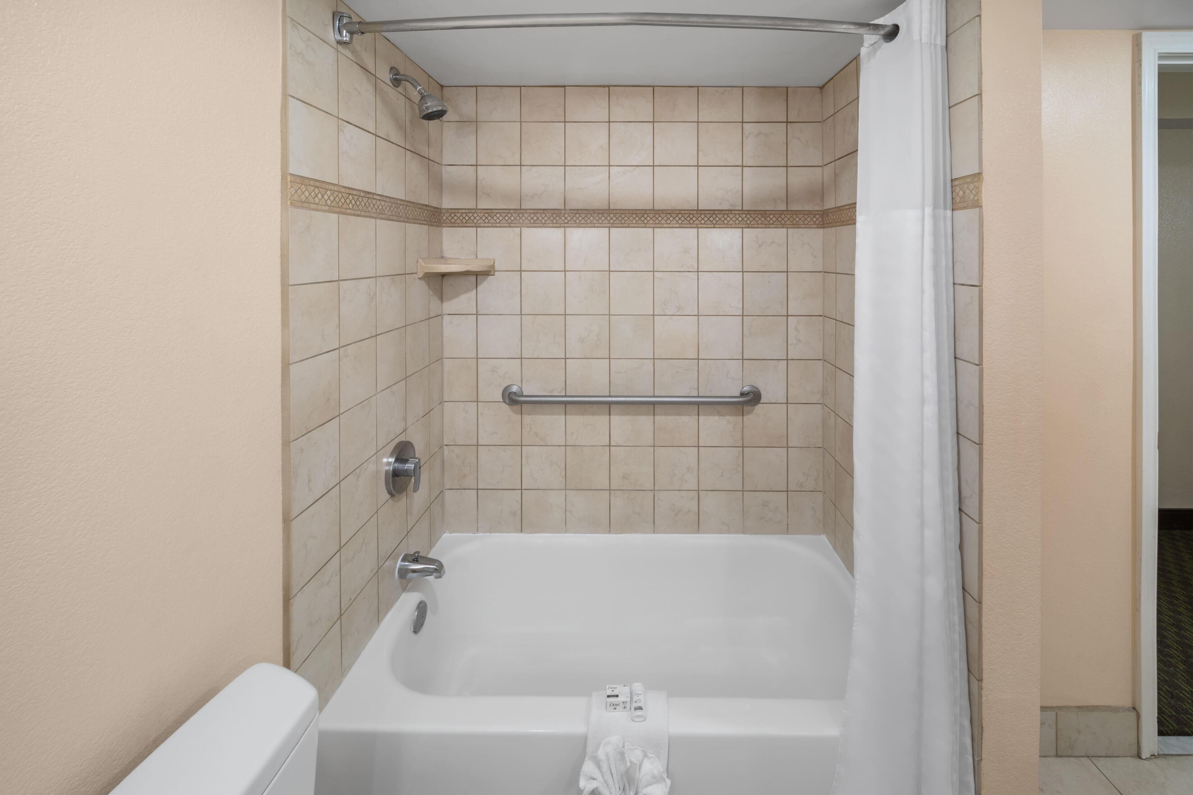 Un baño con bañera, ducha y un perchero para toallas.