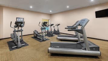 A gym with treadmills, elliptical machines, and a stationary bike.
