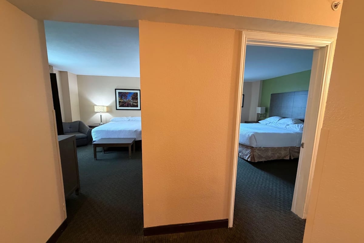 Ein Hotelzimmer mit zwei Betten, einem Schreibtisch und einem Stuhl.