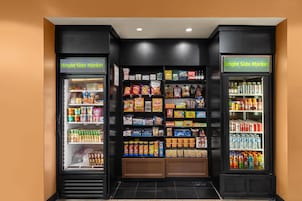 Un área de autoservicio con máquinas expendedoras de aperitivos y bebidas, con múltiples estantes llenos de diversos productos.
