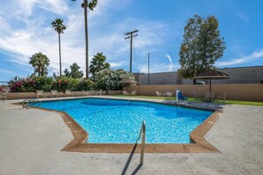 A swimming pool with a clear blue water, surrounded by a concrete deck, and a few lounge chairs. - Rodeway Inn & Suites Blythe I-10 (Blythe)