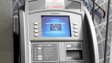 A self-service ATM with instructions for use, a card slot, and a cash dispenser.