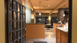 A restaurant interior with a central counter, seating area, and a decorative wall.
