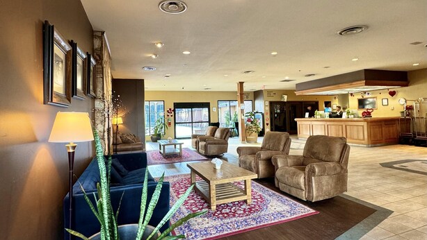 A spacious lobby with a seating area, a reception desk, and a view of the outside.