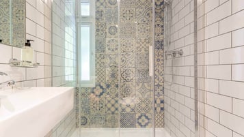 Eenvoudige vierpersoonskamer | Badkamer | Een douche, een haardroger, handdoeken