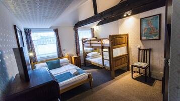 A room with a bed, a bunk bed, a chair, and a map on the wall.