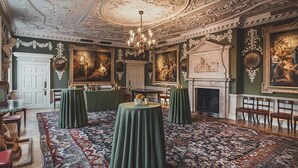 A grand room with ornate ceilings, classical paintings, a fireplace, and green-covered tables. - St Athans Hotel (London)