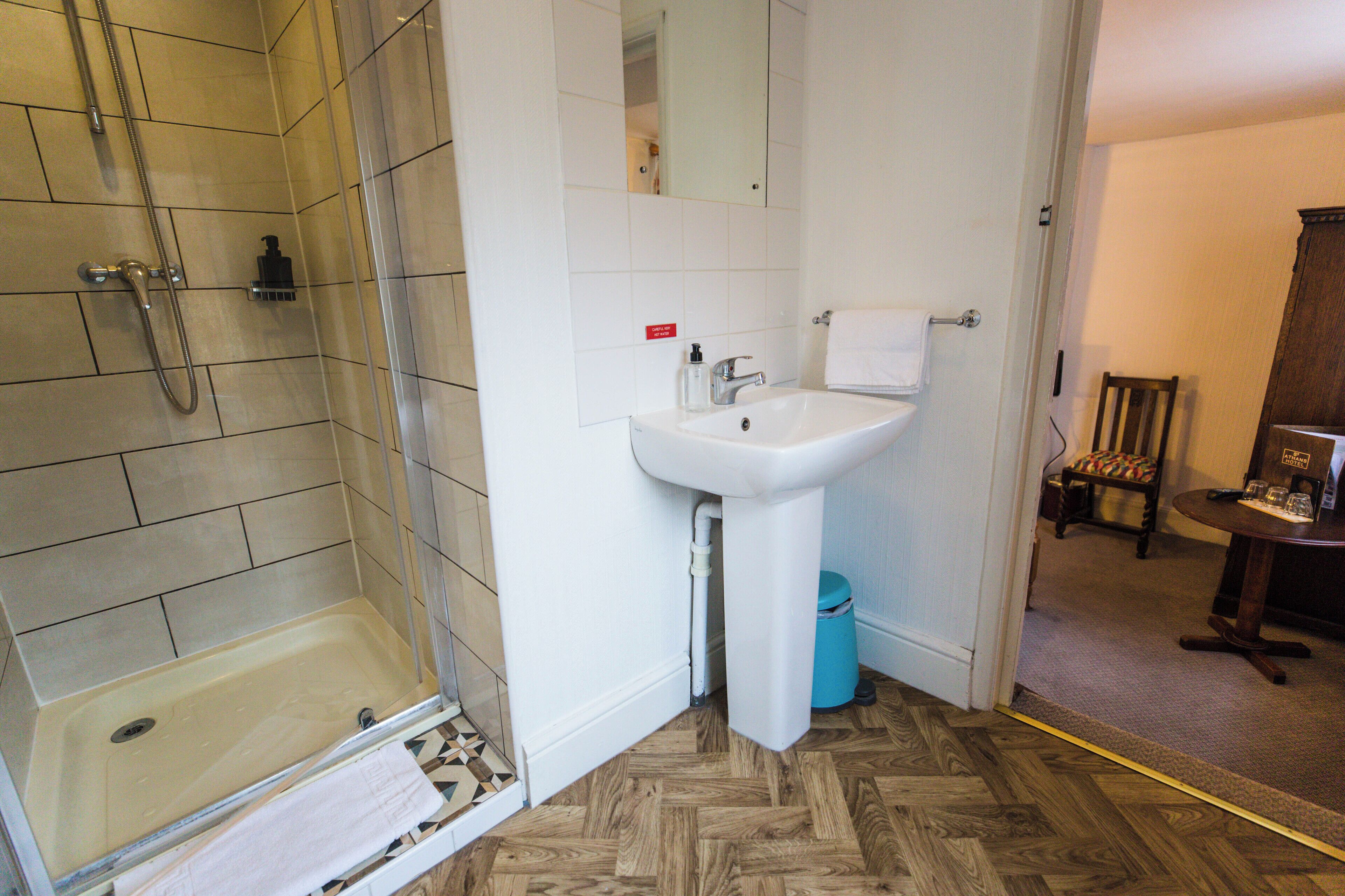 A bathroom with a shower, sink, and mirror.