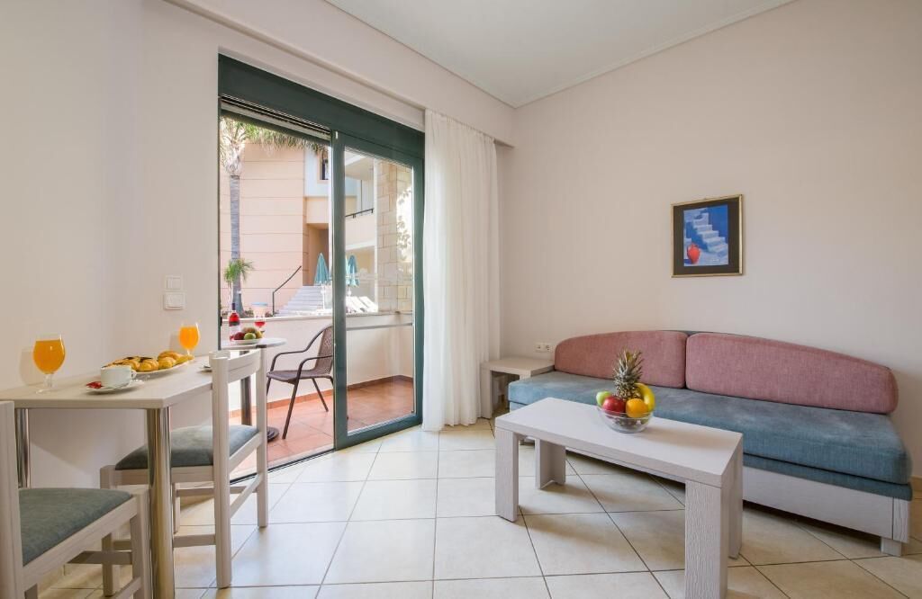 Una sala moderna con sofá, una mesa de comedor con sillas y un balcón con vistas.