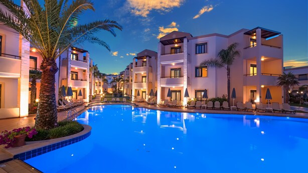 A modern hotel with a swimming pool, multiple balconies, and palm trees. - Creta Palm Hotel (Chania)