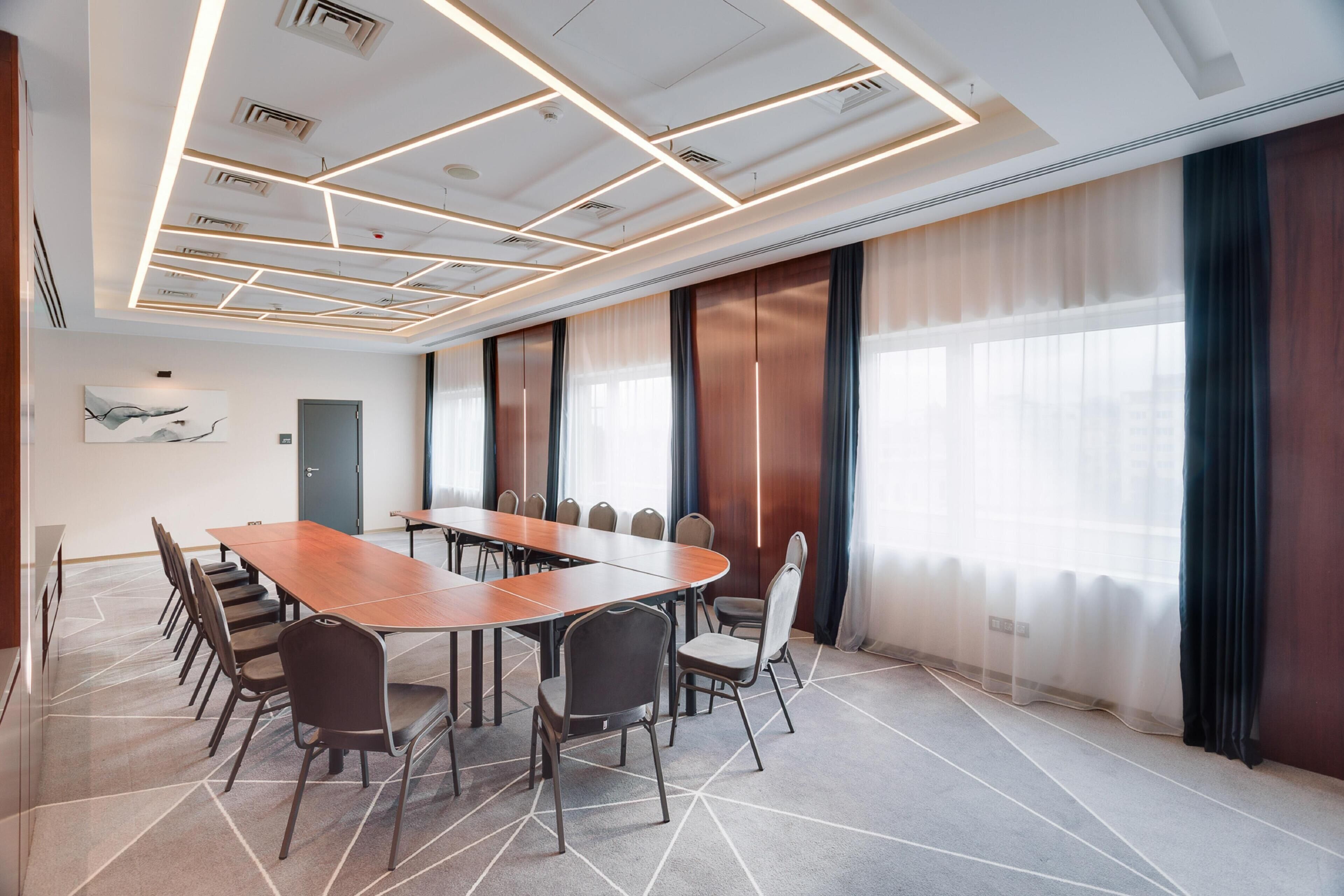 A conference room with a long table, chairs, and a modern ceiling design.