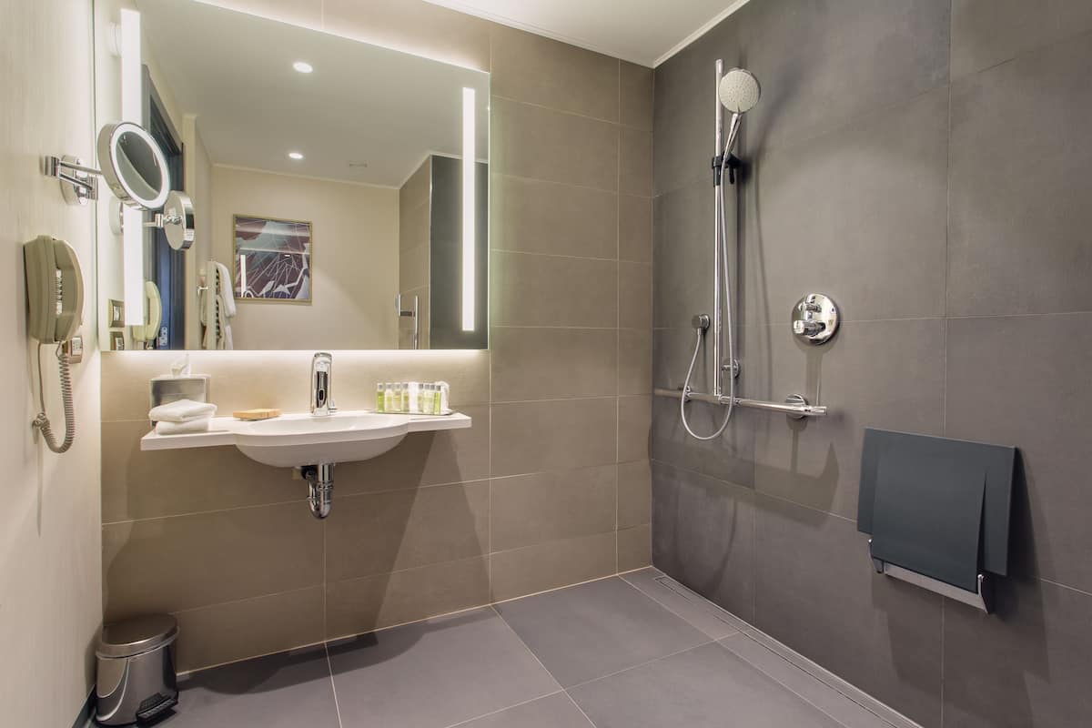 Une salle de bain moderne avec un lavabo, un miroir et une douche.