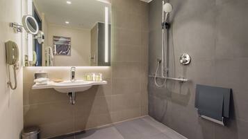 A modern bathroom with a sink, mirror, and shower.
