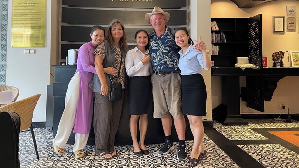 A group of people posing in front of the Orchid Hotel sign in Hue, Vietnam. - Orchid Hotel (Hue)