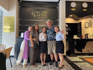 A group of people posing in front of the Orchid Hotel sign in Hue, Vietnam. - Orchid Hotel (Hue)