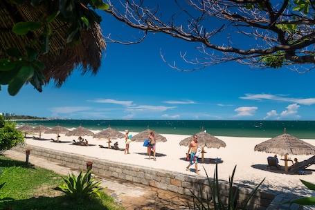 Privat strand, hvit sand, solsenger og parasoller