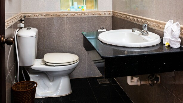 Un baño con inodoro, lavabo y ventana.