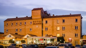 Un hôtel dont l’enseigne, bien visible, porte l’inscription « HÔTEL PALACIOS ».