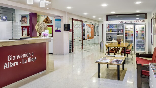 Un espace bar en libre-service avec un comptoir de réception et un coin salon.