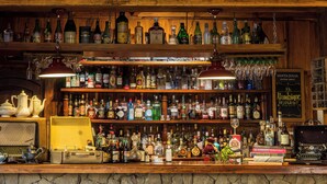 A bar with shelves stocked with various bottles, a vintage typewriter, and a sign reading "Santa Julia Extra Brut."