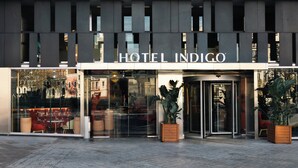 The exterior of Hotel Indigo with a modern facade, large glass windows, and a revolving door. - Hotel Indigo Barcelona Plaza Espana by IHG (Barcelona)